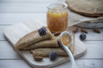 pancakes and orange jam on a light wooden background