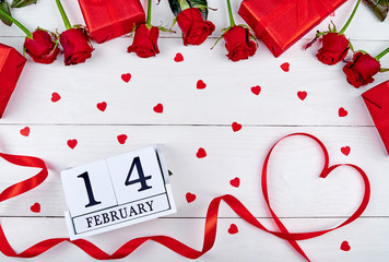 Valentines Day background with red roses, gift boxes, ribbon shaped as heart and wooden block calendar february 14 , copy space. Greeting card mockup. Love concept. Top view, flat lay