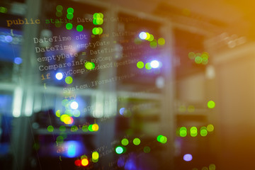 Double exposure of Computer language source code on computer monitor and network server room with...