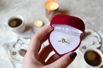 The engagement ring in woman's hand.