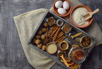 A plurality of spices and cooking utensils. Natural products. Food background. Top view. Rural style.