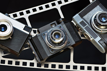 Old retro rangefinder camera on background of film perforation