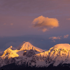 Naklejka na ściany i meble Colorful sunset on the snowy mountains