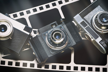 Old retro rangefinder camera on background of film perforation