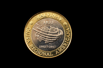 A bimetallic two peso coin from Argentina isolated on a black background