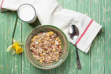 Bowl of oat flakes and glass of milk, on wooden background. Top view.