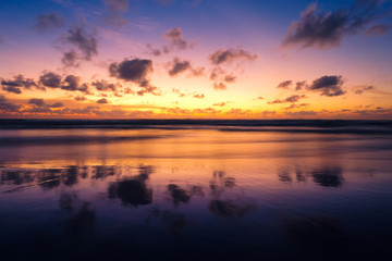 Naklejka premium Beautiful sunset with long exposure effect, motion blurred at Bang Tao Beach, Phuket Island, Thailand.