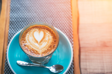 Cup of hot latte art coffee on wooden table.
