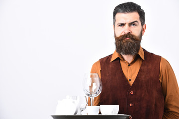 Waiter with white tea cup, pot and glasses on tray.