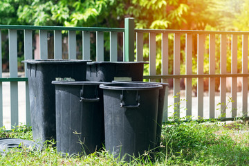 Black plastic trash bin in the garden.