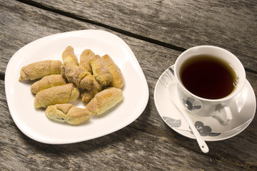 A cup of tea and homemade cookies on an old wooden table