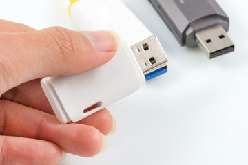 hand holding usb flash, usb memory stick on white.