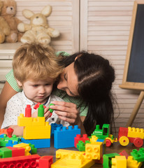 Mother and kid boy playing block toys at home