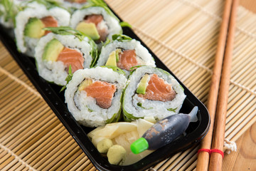 Modern Lachs Avocado Inside Out California Sushi Rolle mit Rucola Topping 