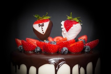 Hochzeitstorte für Luxus Hochzeit mit Erdbeeren Paar im Fokus. Erdbeertorte oder Schokoladentorte Konditorei Kunst setzt Trend mit Drip Cake, Verzierungen für Trauung und heiraten. Symbol der Liebe