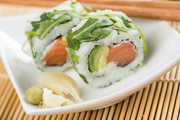 Zwei California Rucola Lachs Avocado Inside Out Sushi mit Stäbchen, Ingwer und Wasabi