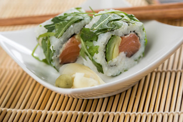 Zwei California Rucola Lachs Avocado Inside Out Sushi mit Stäbchen, Ingwer und Wasabi