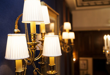 Lamps and chandelier in the classic interior of the hotel
