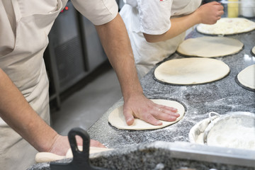 Pizza Art. The process of making pizza. Group cooks make pizza