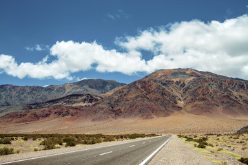 Road to a desert valley with colorful hills in the Andes in Catamarca, Argentina