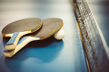 Two ping-pong rackets and white balls on the professional table with net - obrazy, fototapety, plakaty