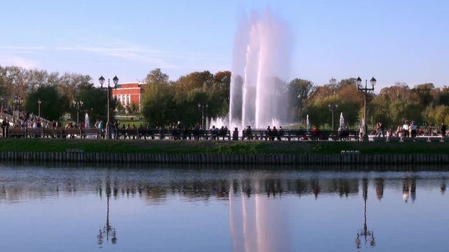 People in park on bench near fountains in summer in Moscow. Beautiful views of capital of Russia.