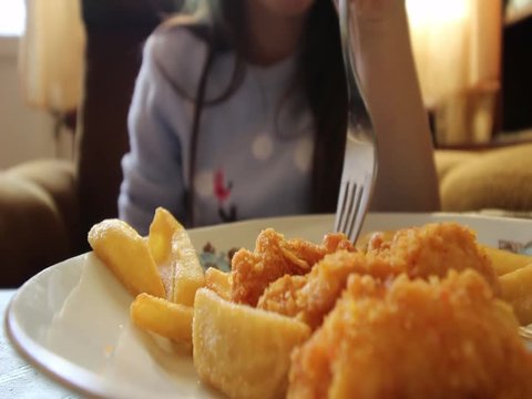     Girl eating fast food - french fries and chicken meat, close up, food is on focus, hd video 