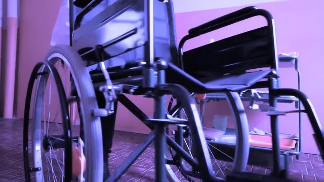 Nurse and empty wheelchair parking in old hospital, purple filter