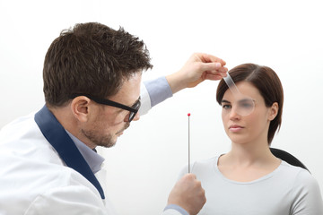 optometrist examining eyesight, woman patient pointing at the sphere, Nsuco saccadic movements test