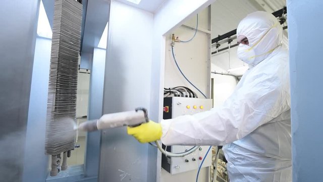 industrial metal coating. Man in protective suit, wearing a gas