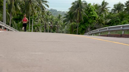 fitness woman running at tropical forest trail