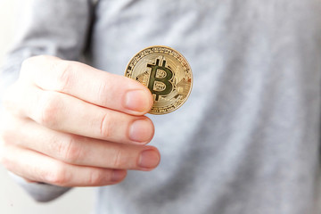 Cryptocurrency golden bitcoin coin in man hand. Electronic virtual money for web banking and...