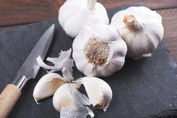 Garlic on slate next to knife. Food