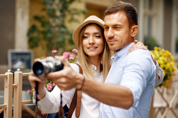 Tourist Couple Taking Photos On Camera On Street.