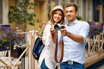 Tourist Couple Taking Photos On Camera On Street.