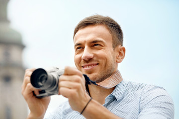 Male Photographer Taking Photos On Camera On Street