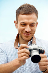 Fototapeta premium Male Photographer Taking Photos On Camera On Street