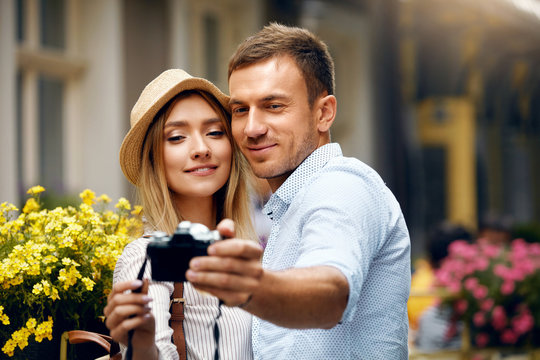 Beautiful Couple Taking Photos With Camera On Street.