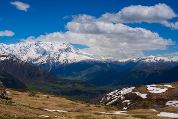 Clouds float above the valley among the snow-capped mountains