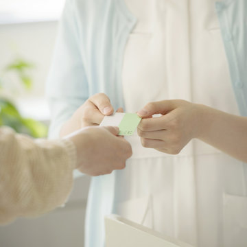 診察券を受け取る女性職員の手元