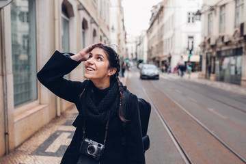 Fototapeta premium Female traveler woman walking streets of European capital.Visitor in Lisbon,Portugal.Traveling Europe on a budget.Studying abroad.Student discount for traveling concept