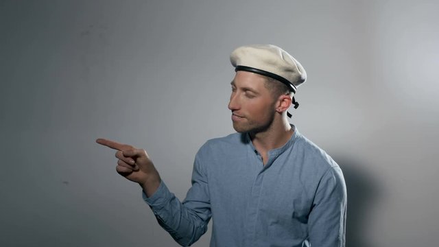 Portrait of a Male Model Wearing a Beret and Pointing Profile
