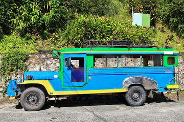 Filipino green-blue-yellow dyipni-jeepney car stationed in Banaue town-Ifugao province-Philippines. 0054