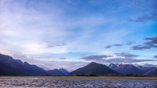 Glenorchy Sunset Time lapse with colorful clouds moving against the beautiful mountain range at lake Wakatipu, New Zealand, on a relatively windy evening making the waves of the lake more prominent.