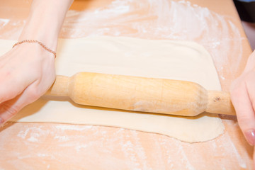 The girl rolls out the dough