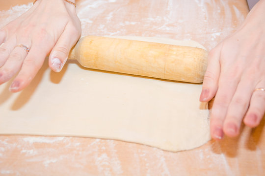 The girl rolls out the dough