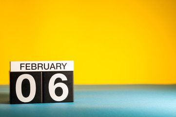 February 6th. Day 6 of february month, calendar on yellow background. Winter time. Empty space for text