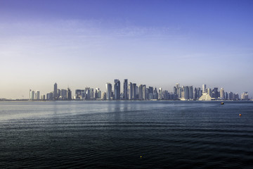 Fototapeta na wymiar Doha, QATAR -DECEMBER 25, 2016: Doha skyline through the sea from the Museum of Islamic Arts. (MIA)