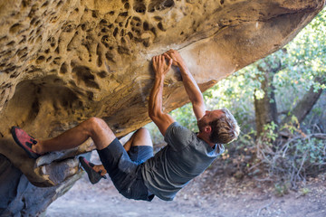 Man Bouldering Outside in a Cave - obrazy, fototapety, plakaty