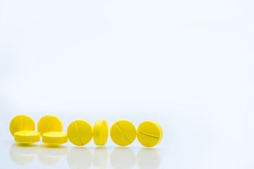 Yellow tablets pills isolated on white background with copy space. Pile of medicine. Painkiller tablets pills.